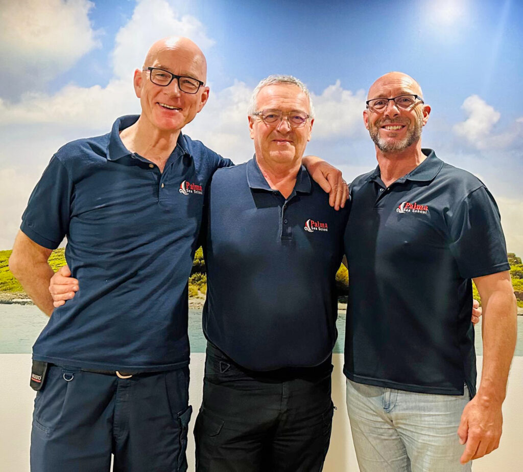 Palma Sea School instructors and RYA Examiners John O’Hara, Simon Bradshaw, and Steve Ginger standing together.